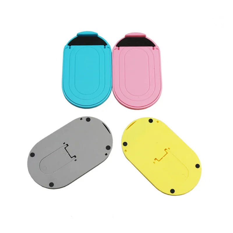 Plastic mobile phone stand with adjustable bracket in six colour options on a wooden desk