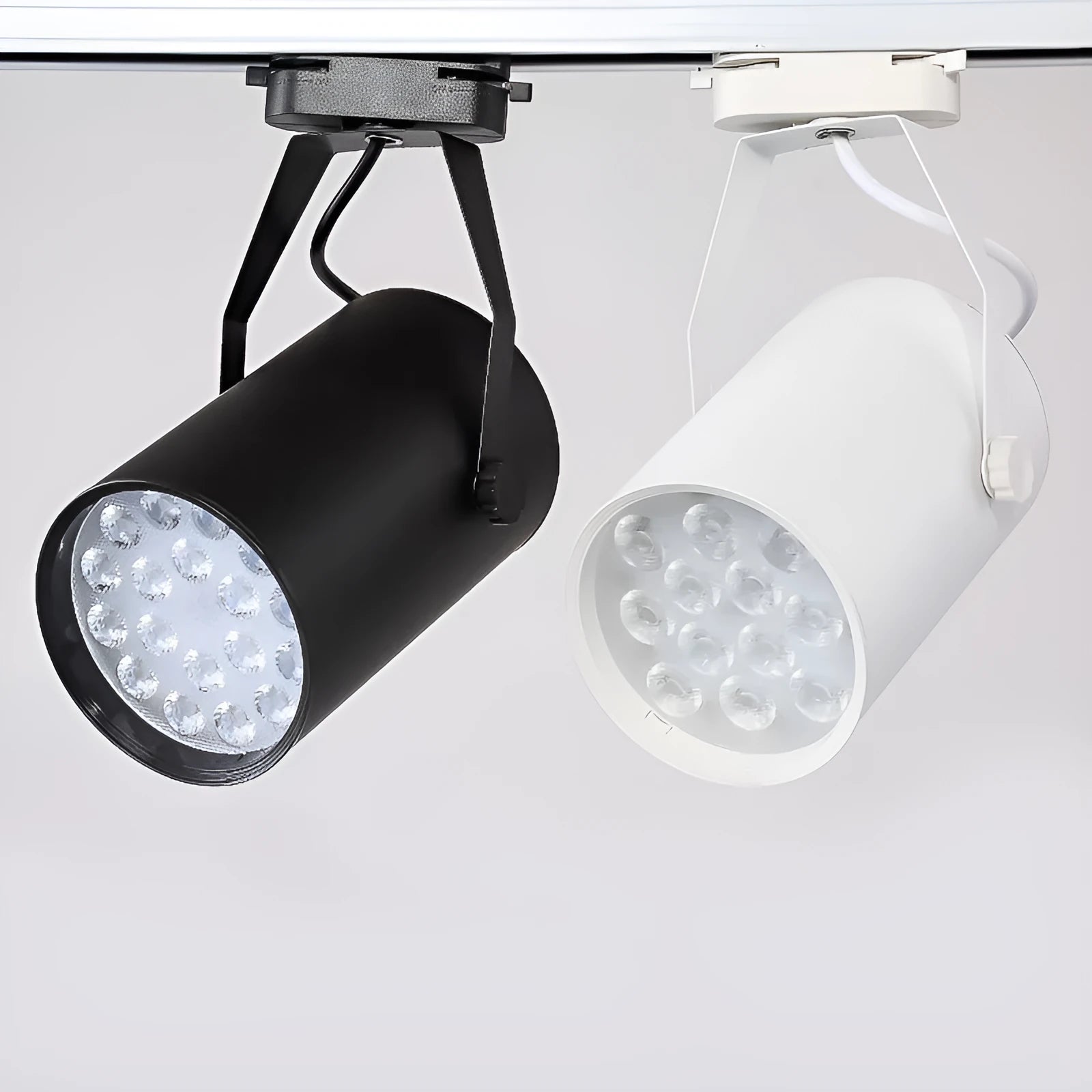 Black aluminium LED track spotlight with sliding head mounted on a track for wall lighting.
