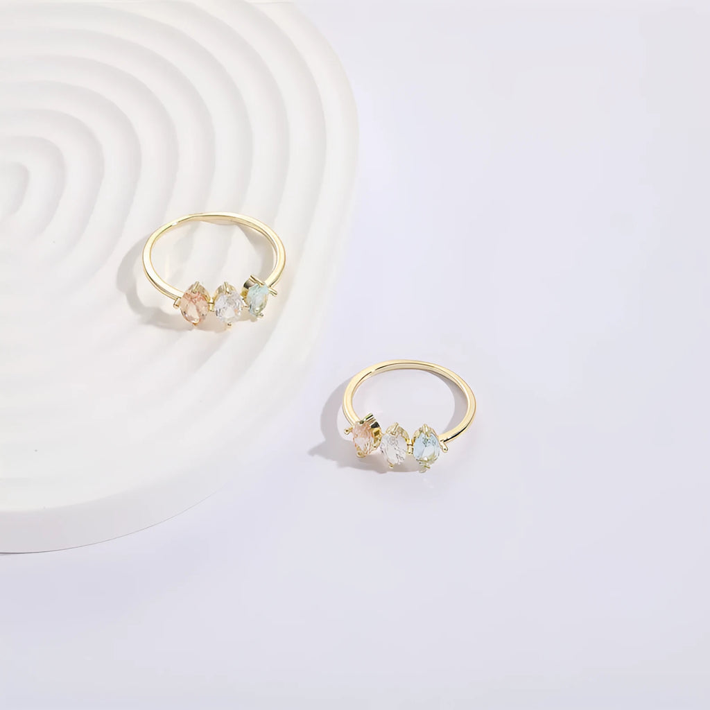 Gold geometric women's ring with horse eye design and three coloured zircon stones on a triangular band.