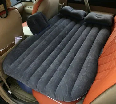 Black inflatable car bed with flocking surface and two pillows, shown folded next to a storage bag.