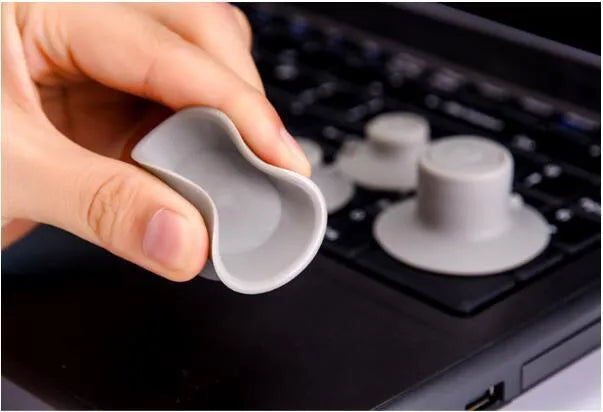 Set of four grey plastic laptop cooling pads: two large and two small, on a desk.