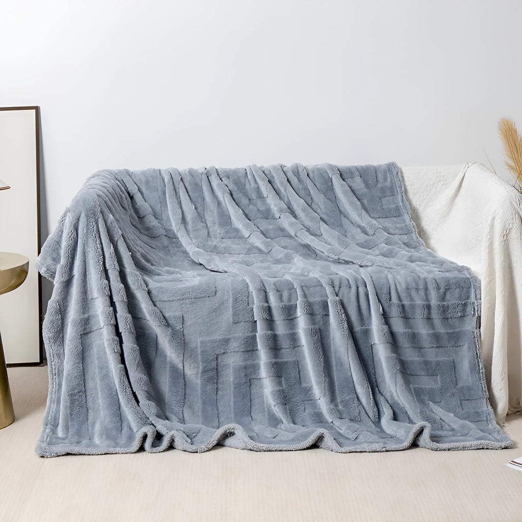 Thick coral fleece sofa blanket in a choice of colours and sizes draped over a grey sofa