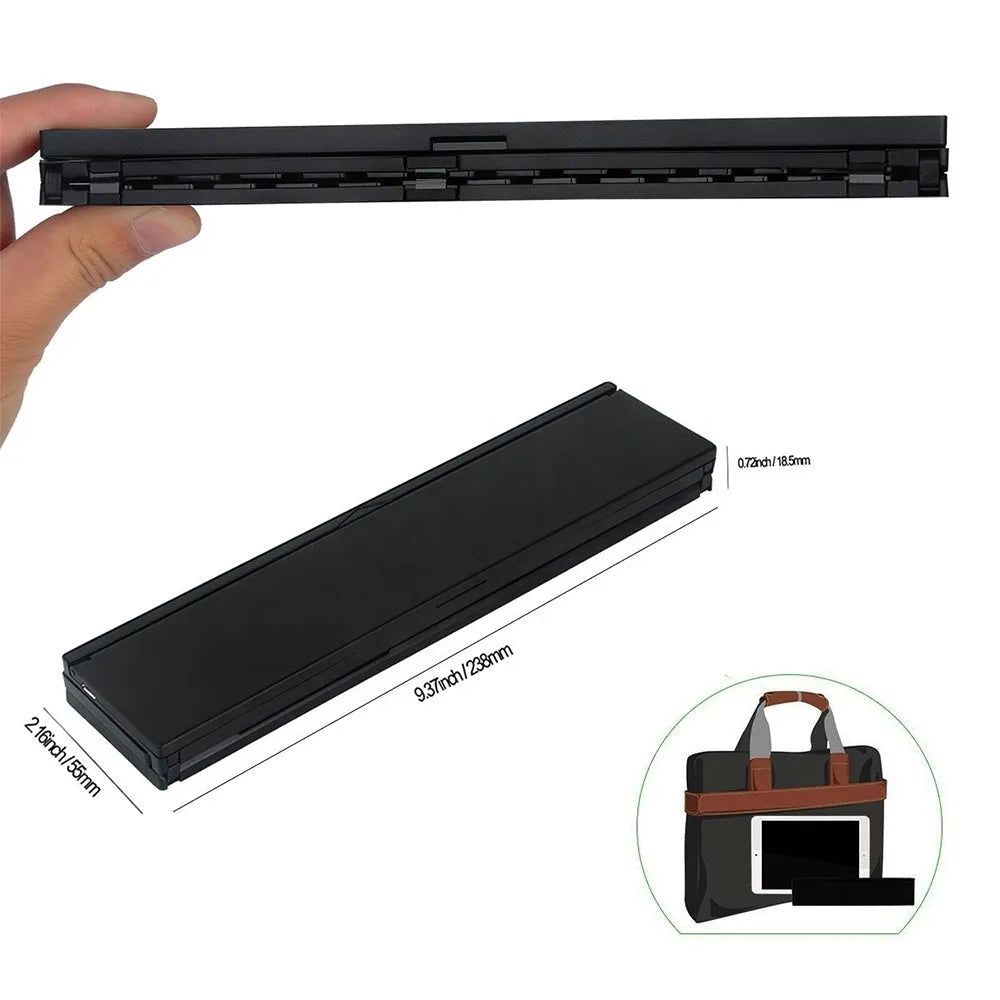 A black mini folding wireless Bluetooth keyboard shown open next to a tablet.