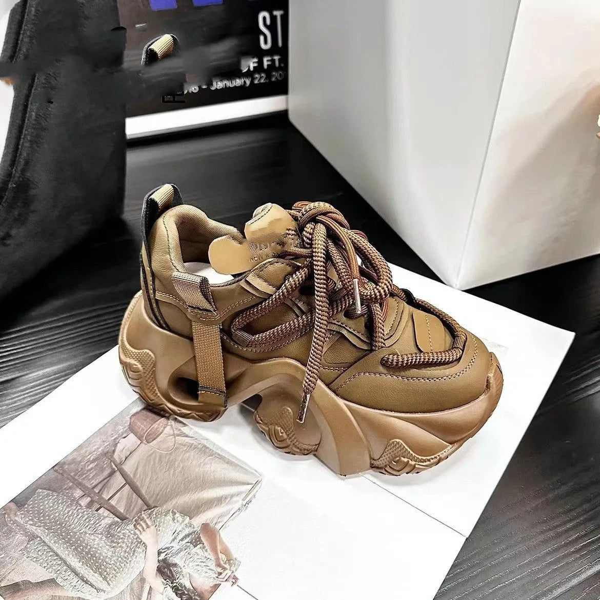 Women's white sneakers with cross straps and a hidden wedge heel on a wooden floor