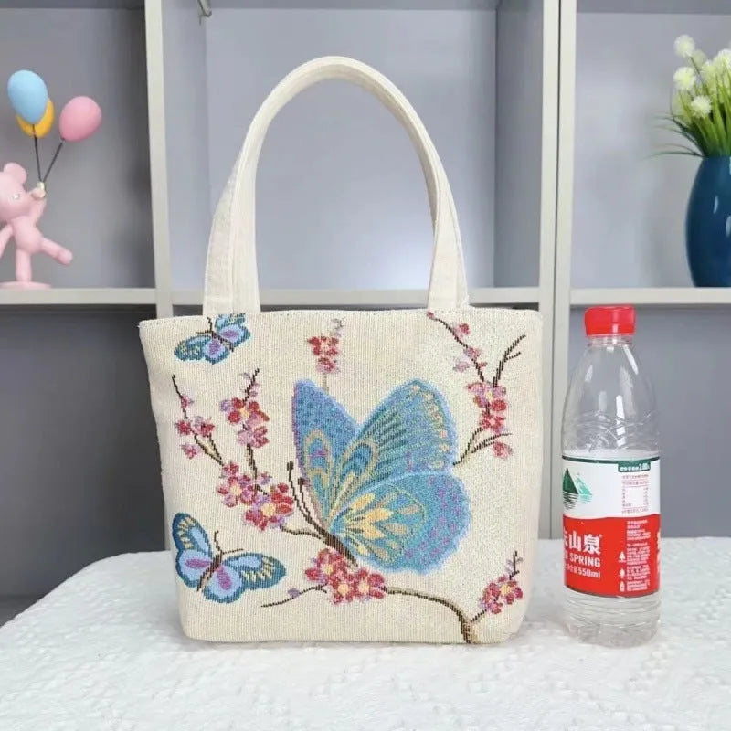 Handheld canvas bag with gold wire embroidery, shown in one of seven colour designs.