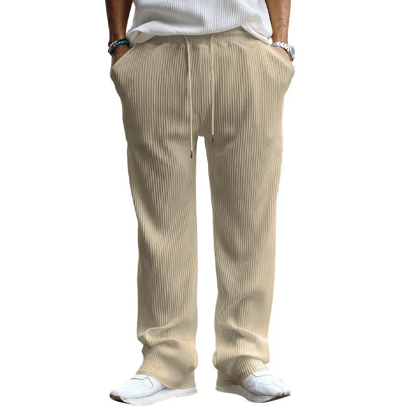 Man wearing loose-fit, high-waist, straight-leg casual trousers in a striped pattern.