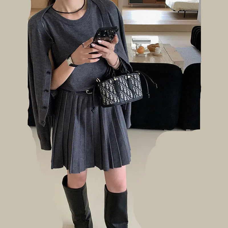 Women's black knitted polyester vest skirt and long sleeve cardigan two-piece set with a belt.