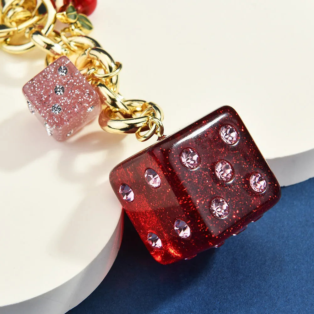 Square cherry two-tone dice keychain pendant on a metal ring.
