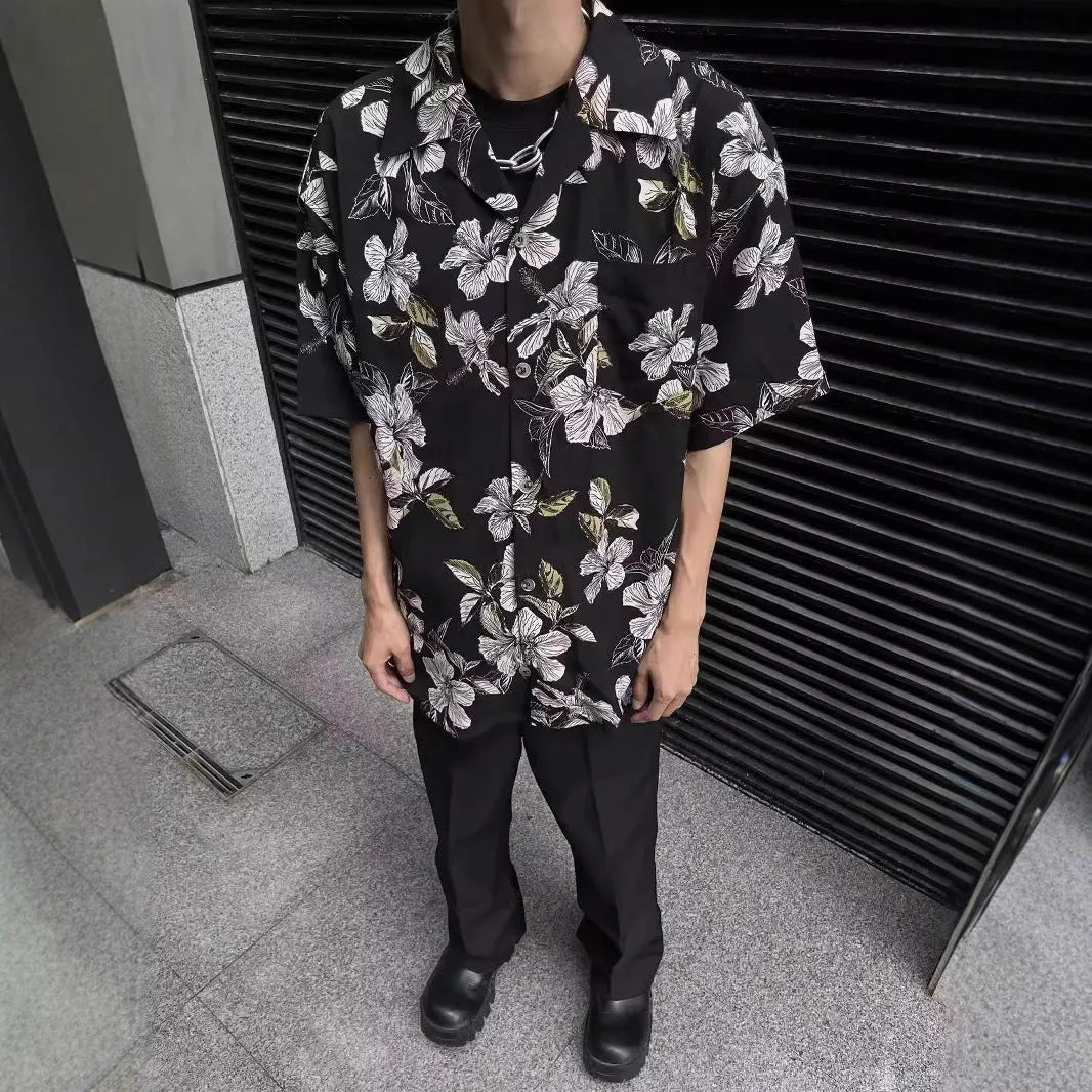 Black men's ice silk shirt with floral print, vintage Cuban collar, and short sleeves on a hanger.