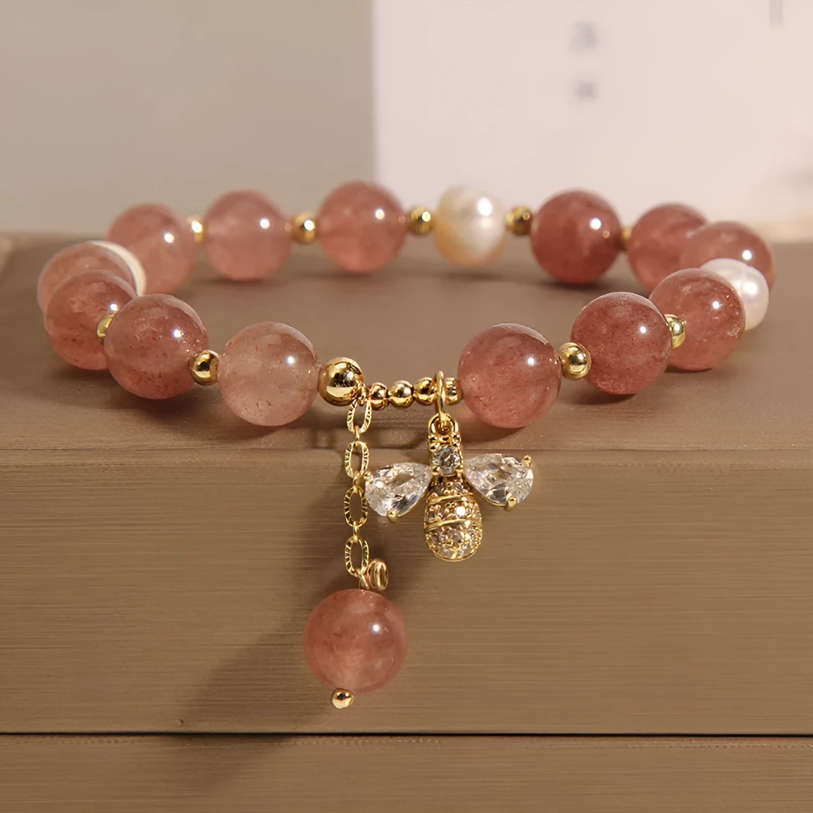 Women's strawberry quartz and freshwater pearl bracelet with zircon bee charm in Japanese-Korean jewellery style