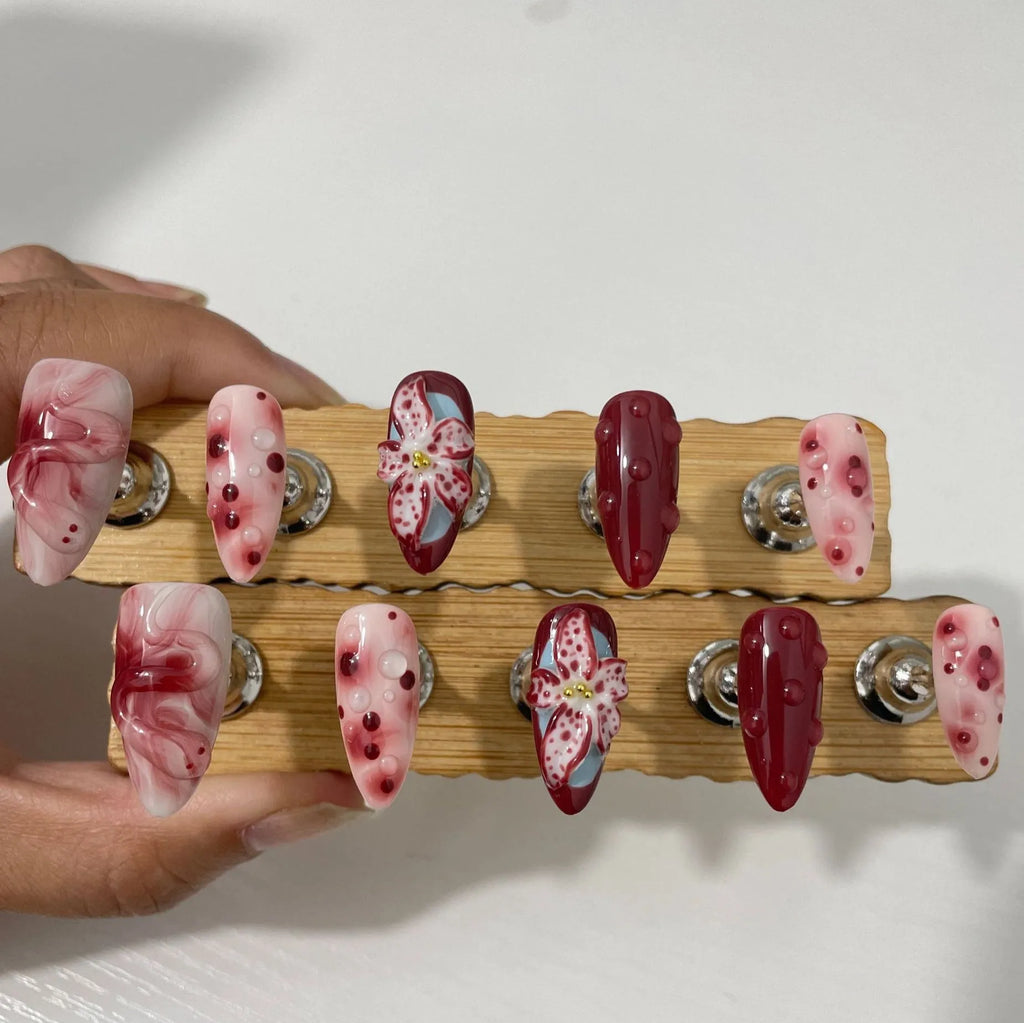 Hand-painted three-dimensional carved almond colour wear nails showing rose pattern in medium length