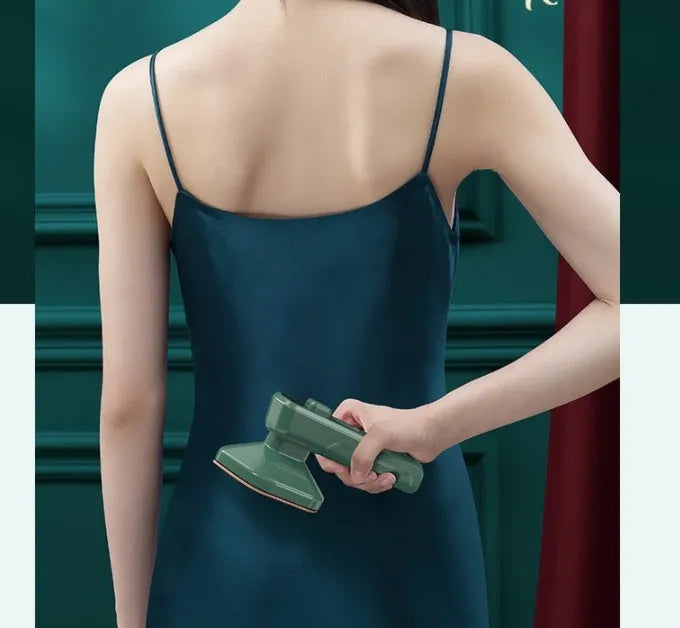 Dark green portable hand-held hanging steam ironing machine with a ceramic panel, shown with a power plug.