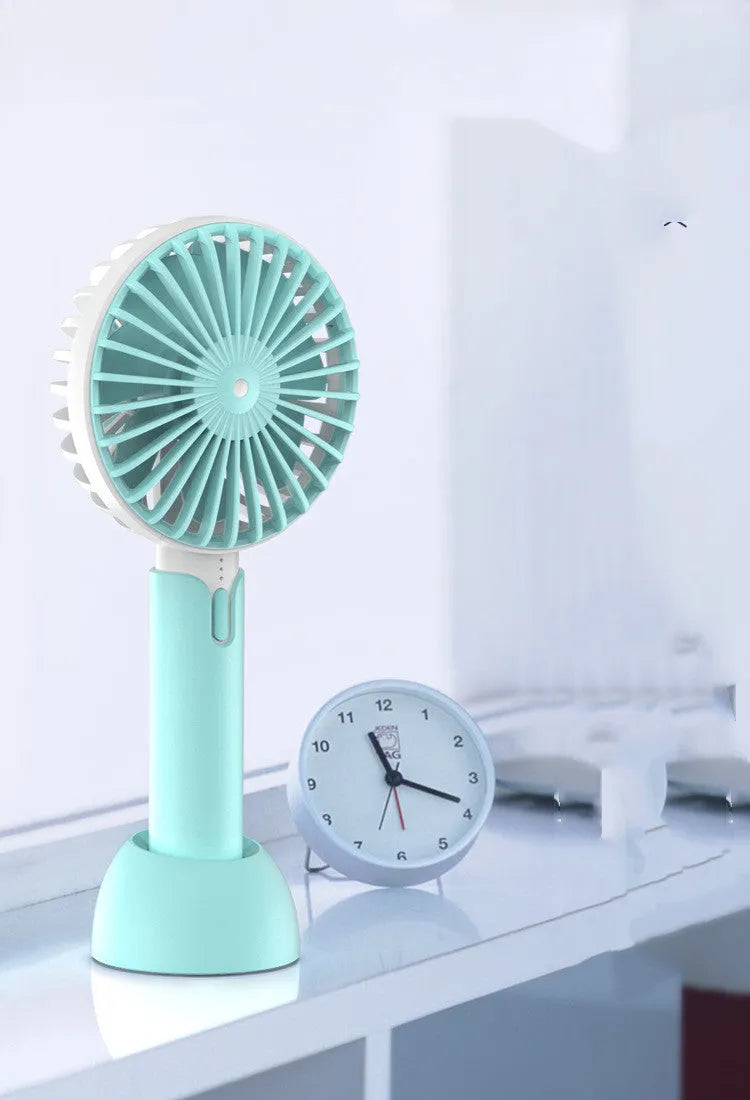 Blue mini handheld and desktop USB electric fan with oscillation on a table