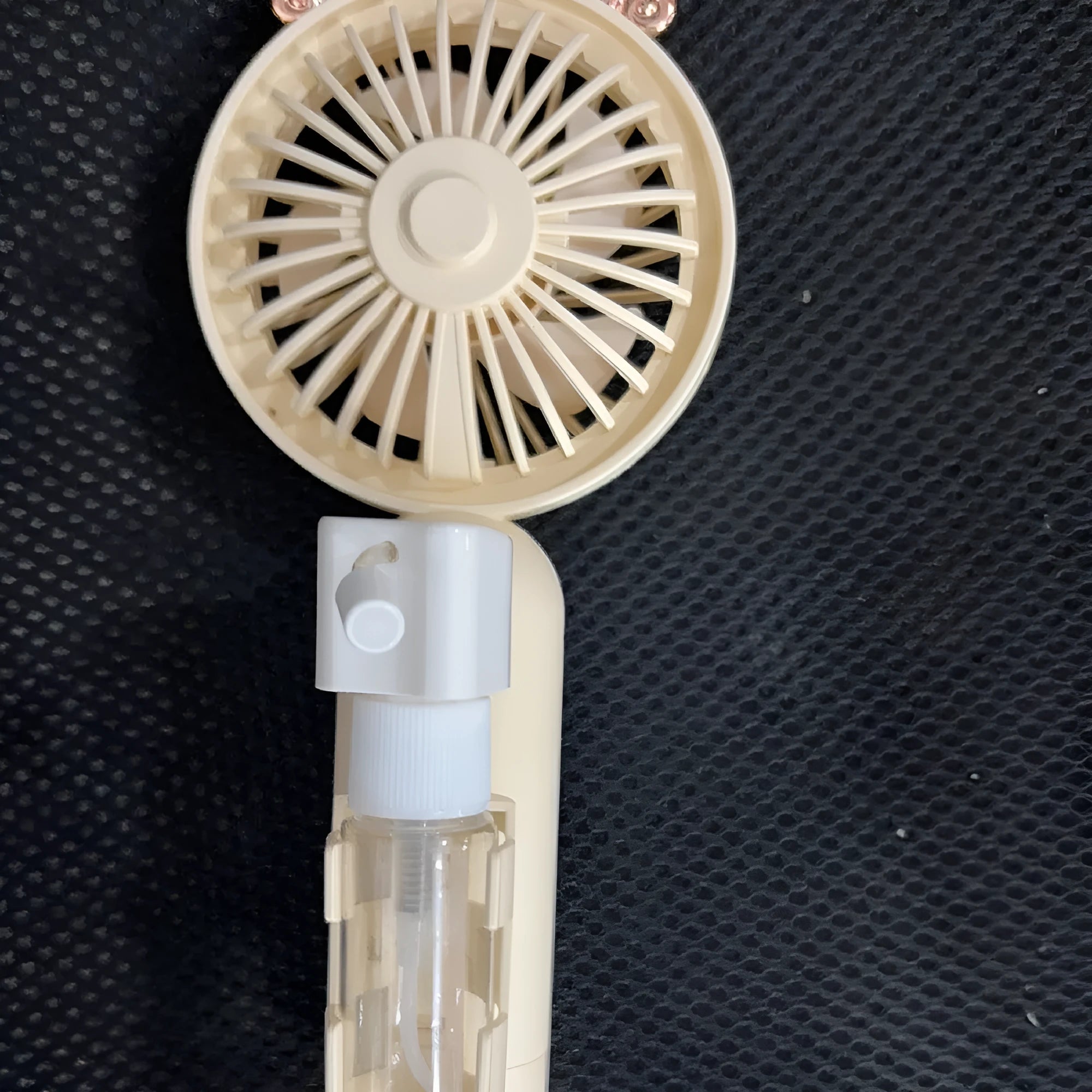 Personalised plastic handheld desk fan with USB port in apricot colour, showing scale.