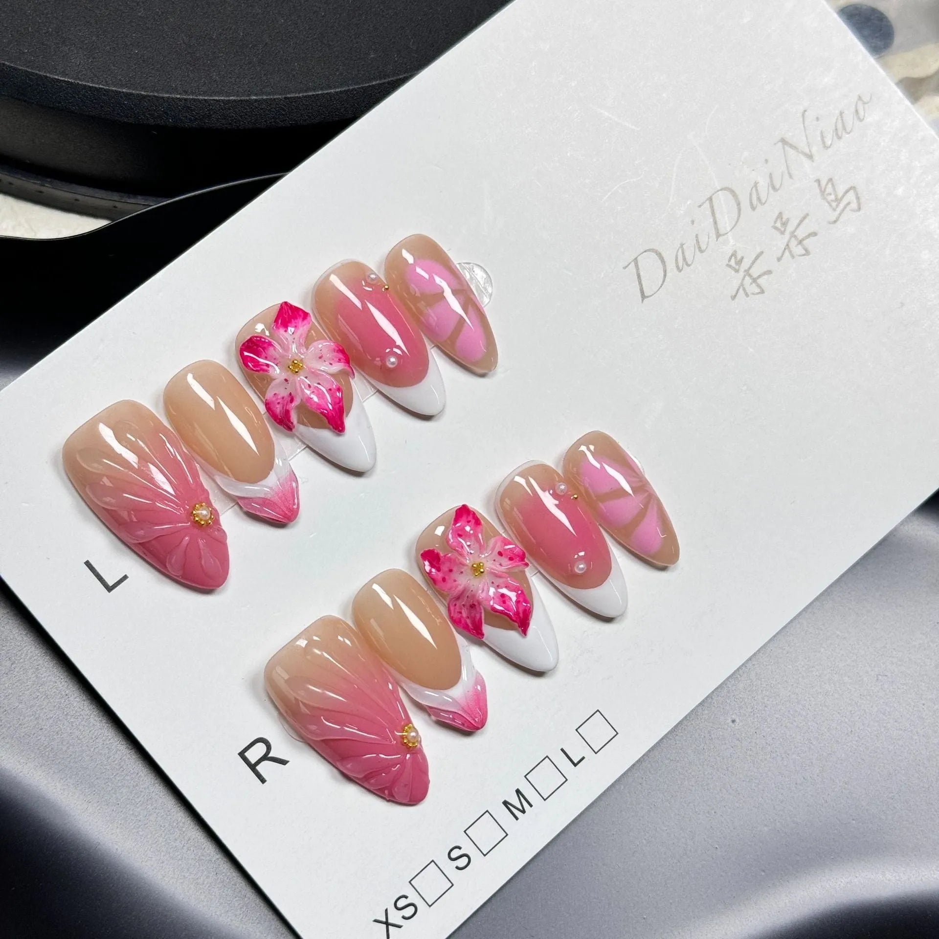 French style three-dimensional lily ice flower gel nail stickers in almond shape on plastic backing.