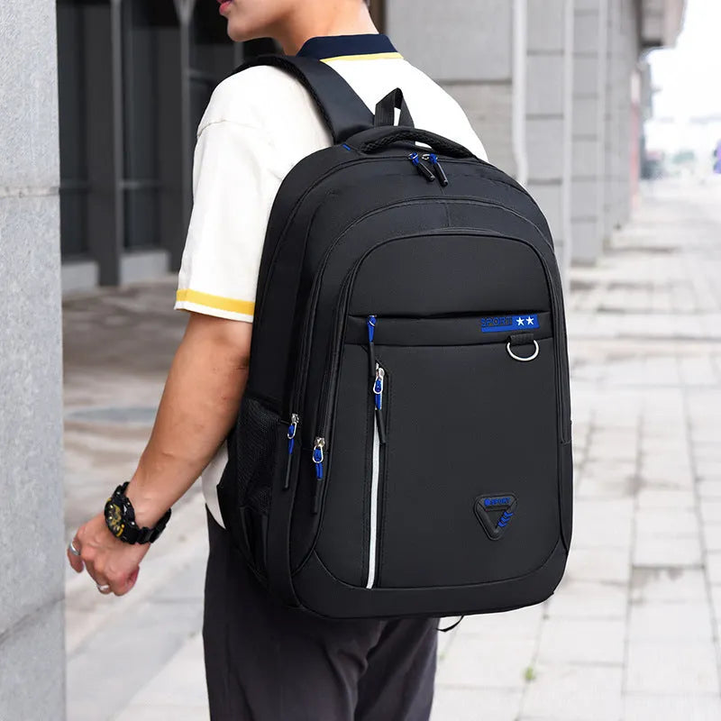 Men's large Oxford cloth schoolbag in black with letter pattern, showing air pillow belt and splicing detail.