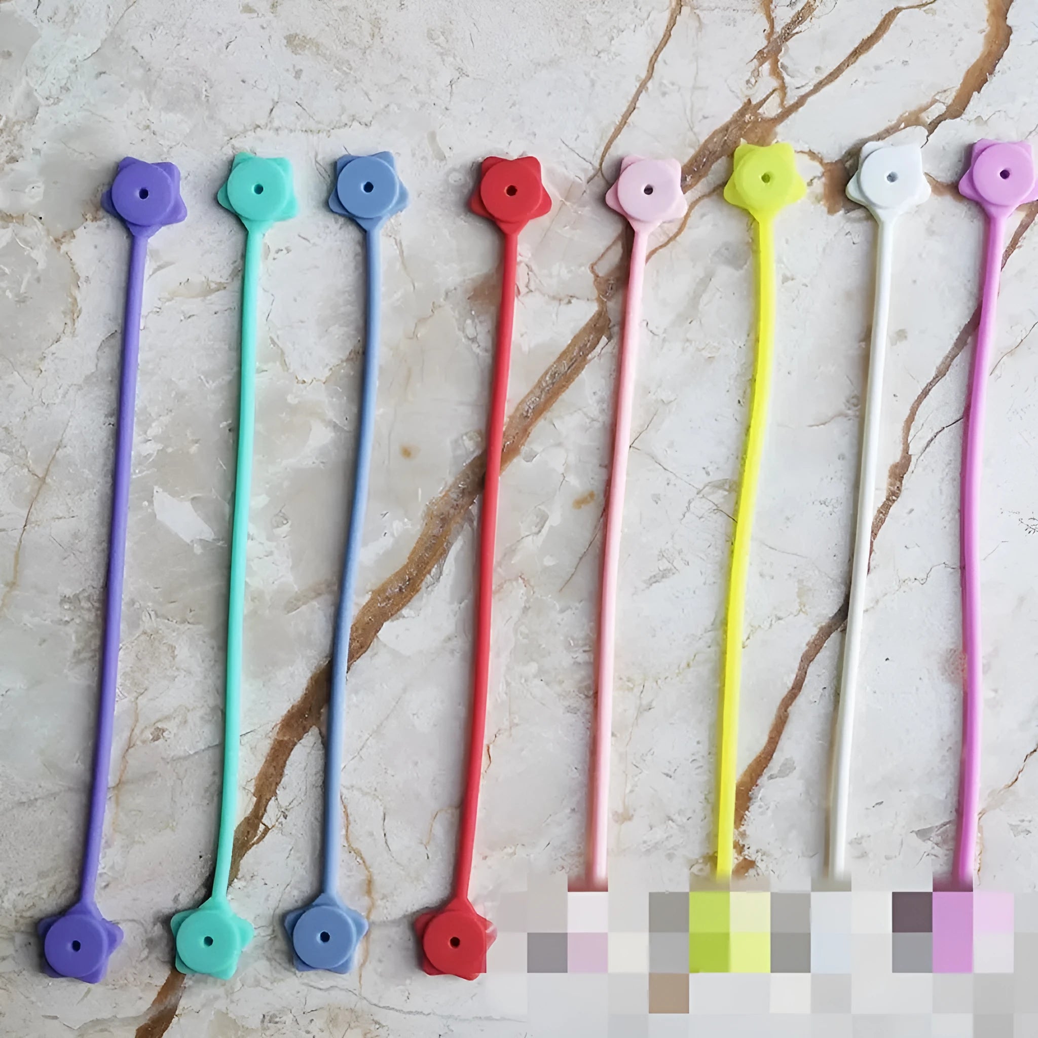 Purple silicone star-shaped magnet winder for clipping onto and organising headphone or phone charging cables.