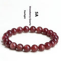 Natural strawberry quartz bracelet with geometric red crystal beads on a white background