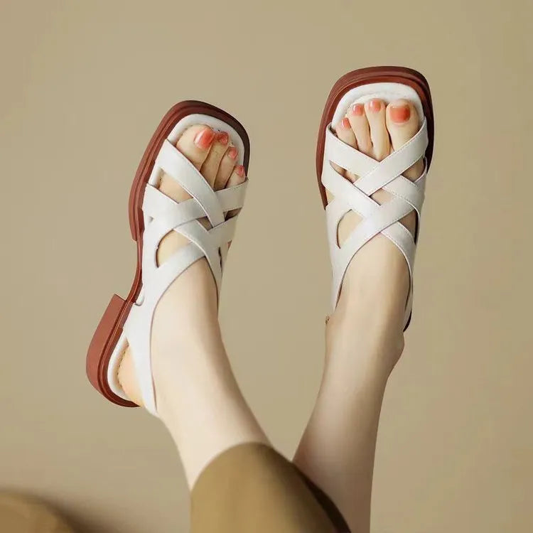Women's glossy patent leather low heel sandals with square toe and cross-strap in black, brown and white.