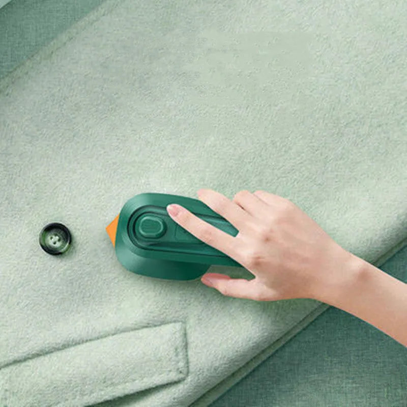 Dark green portable hand-held hanging steam ironing machine with a ceramic panel, shown with a power plug.