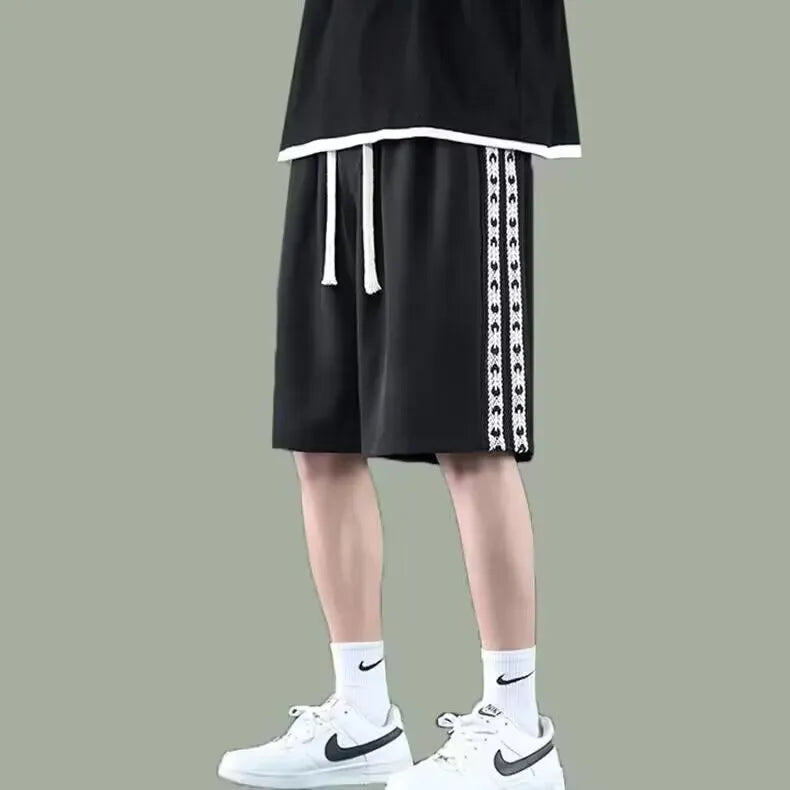 Men's black loose-fit micro-elastic track pants shown in a casual standing pose.