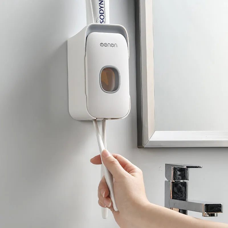 Blue automatic toothpaste dispenser with infrared sensor mounted on a bathroom wall.