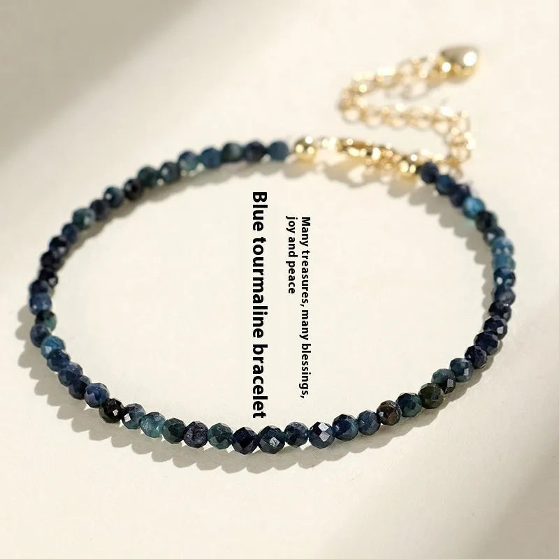 Close-up of a women's blue tourmaline bracelet with 3mm beads and gold spacer beads.