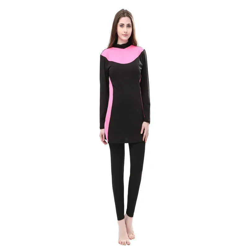 Women's black long sleeve hooded swimsuit with separate pants, shown on a model.