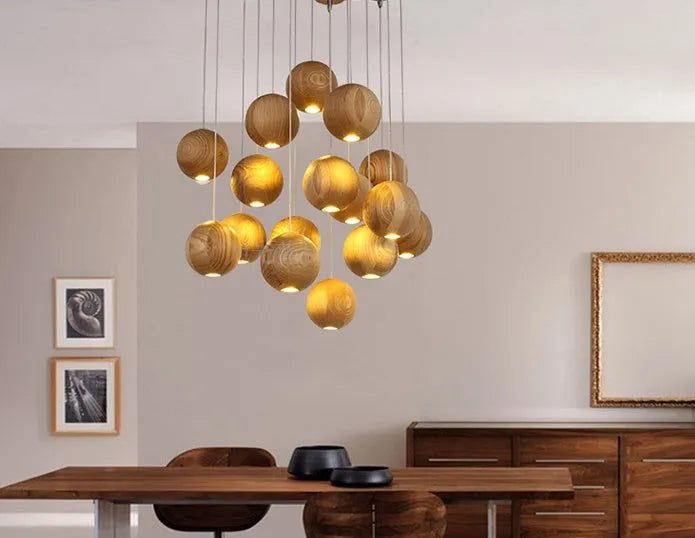 Nordic solid wood ball chandelier hanging lamp with adjustable cord over a dining table.