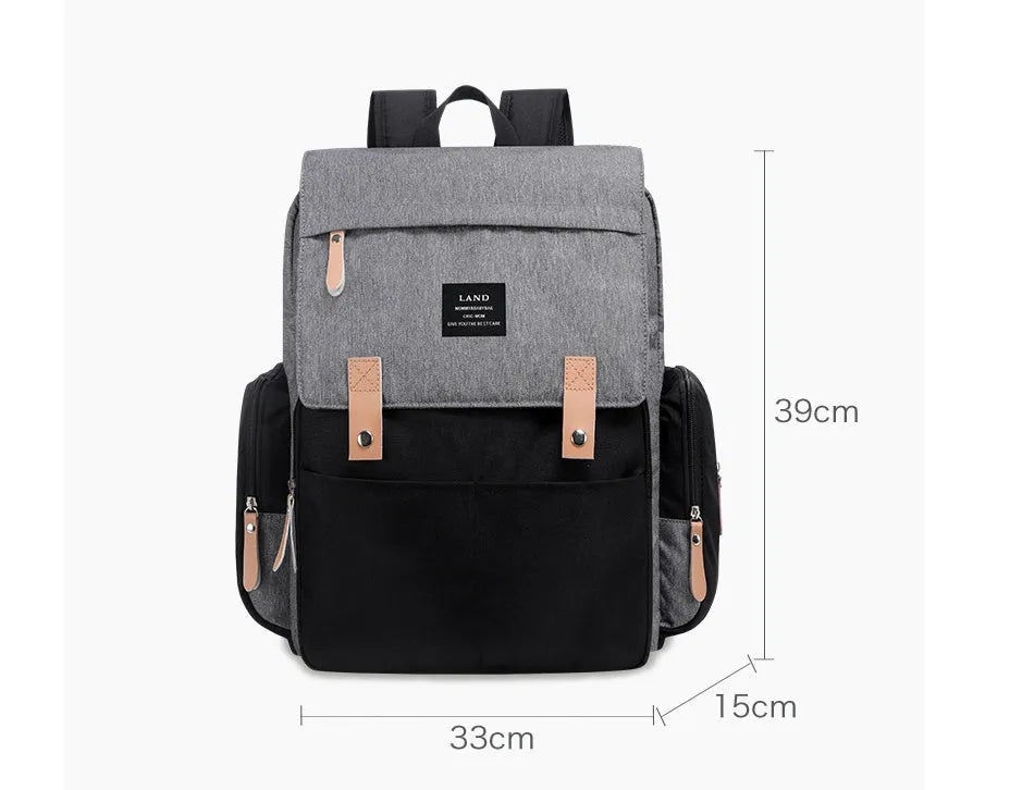 LAND Mommy large grey diaper backpack with changing mat, shown with baby care items.