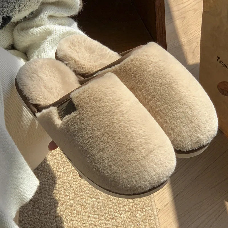 A pair of solid colour plush winter slippers with a non-slip PVC sole and car stitching detail.