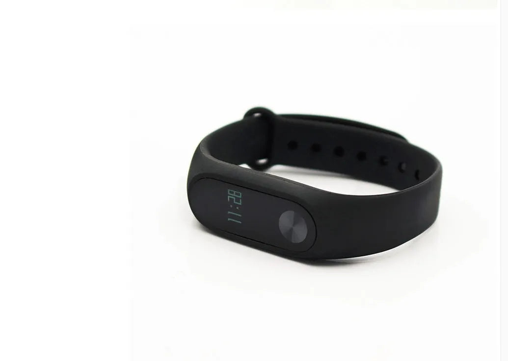 Black Xiaomi Mi Band 2 fitness tracker on wrist showing OLED display with heart rate data.