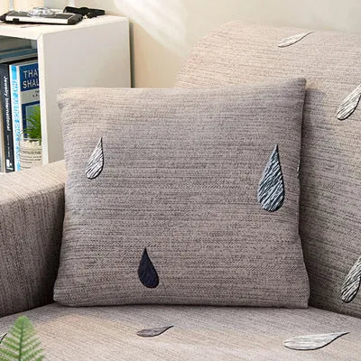 Geometric abstract printed stretch sofa slipcover covering a three-seater sofa with matching cushion covers.