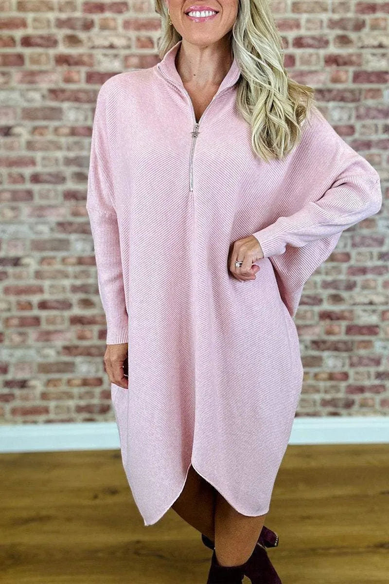 Women's solid colour loose fit knitted dress with raglan sleeves on a model.