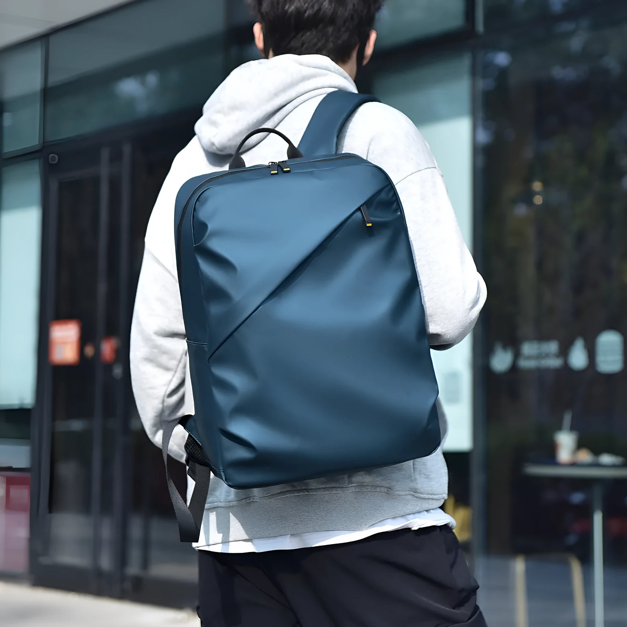 Men's large waterproof PU backpack in black, blue, or grey showing sewing thread details