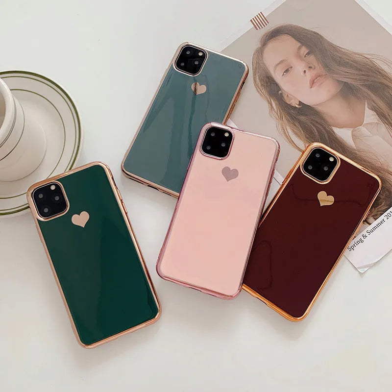 TPU iPhone case with solid colour and a raised metallic love heart design on the back.