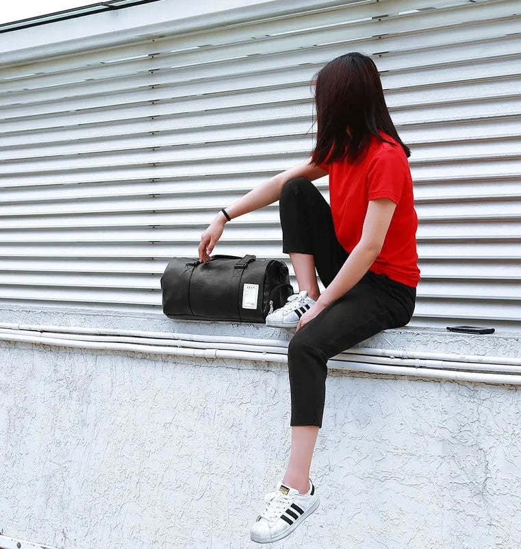 Black waterproof sports fitness bag with diagonal straps and separate internal shoe compartments.