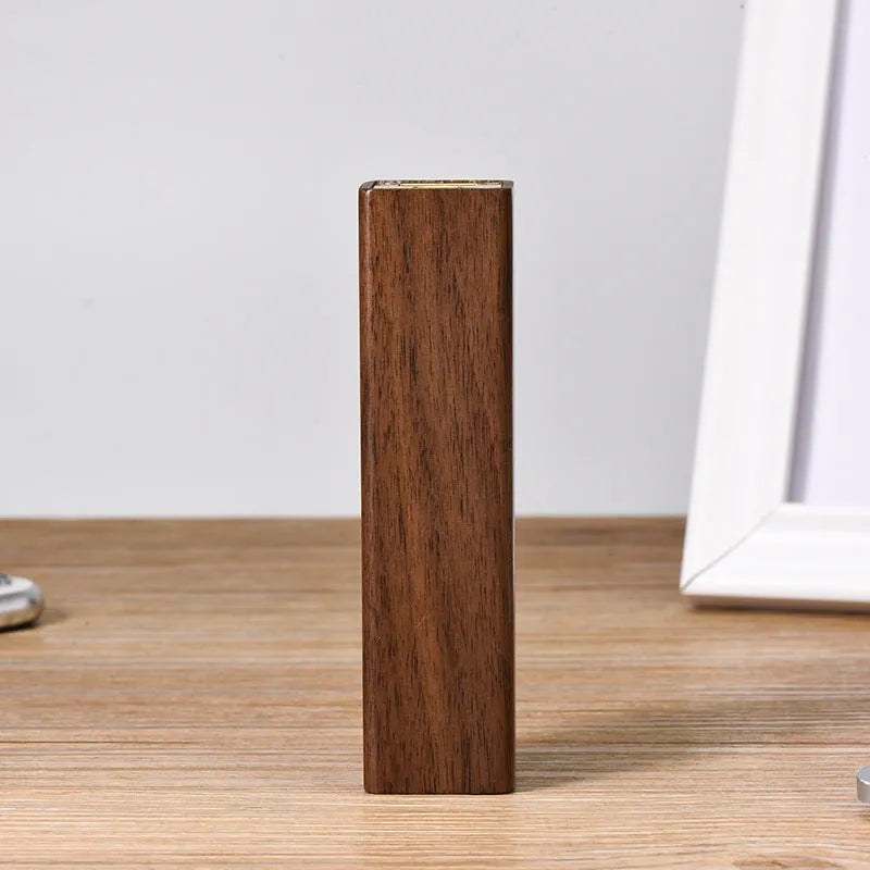 Brown black walnut wood portable power bank showing size next to a charging cable