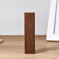 Brown black walnut wood portable power bank showing size next to a charging cable