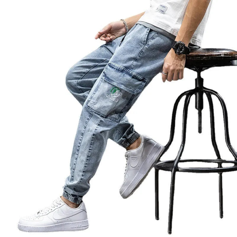 Man wearing loose fit blue cargo jeans with a straight leg and skinny ankle opening.