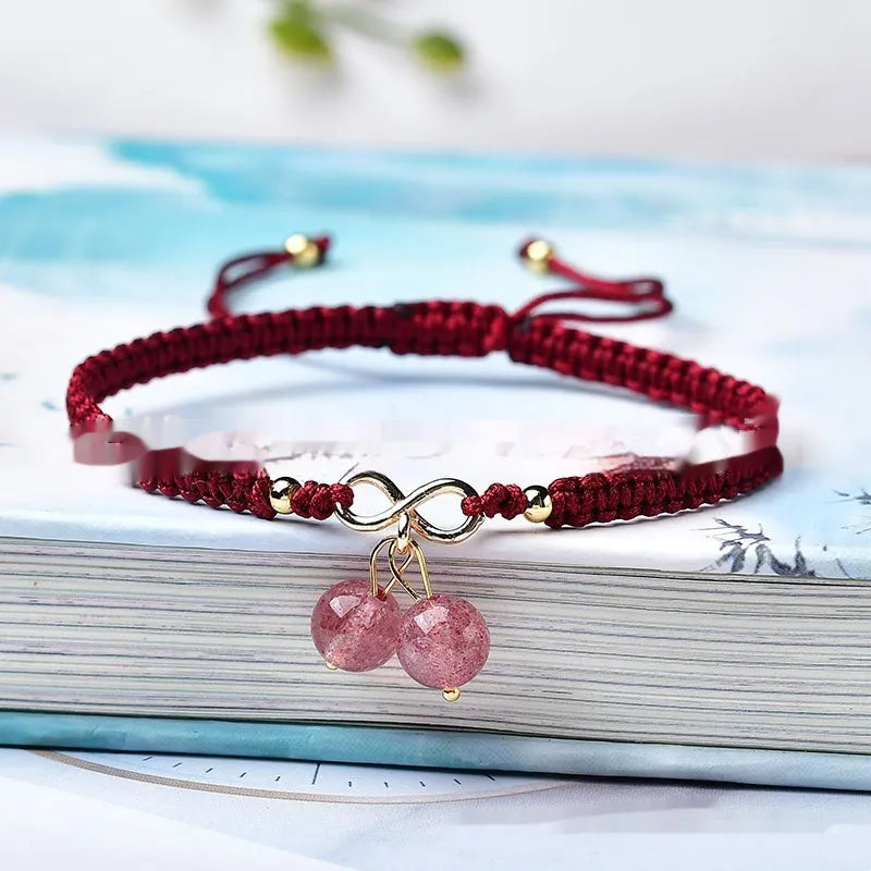 Women's natural strawberry quartz bracelet with a fruit-shaped crystal charm on wrist.