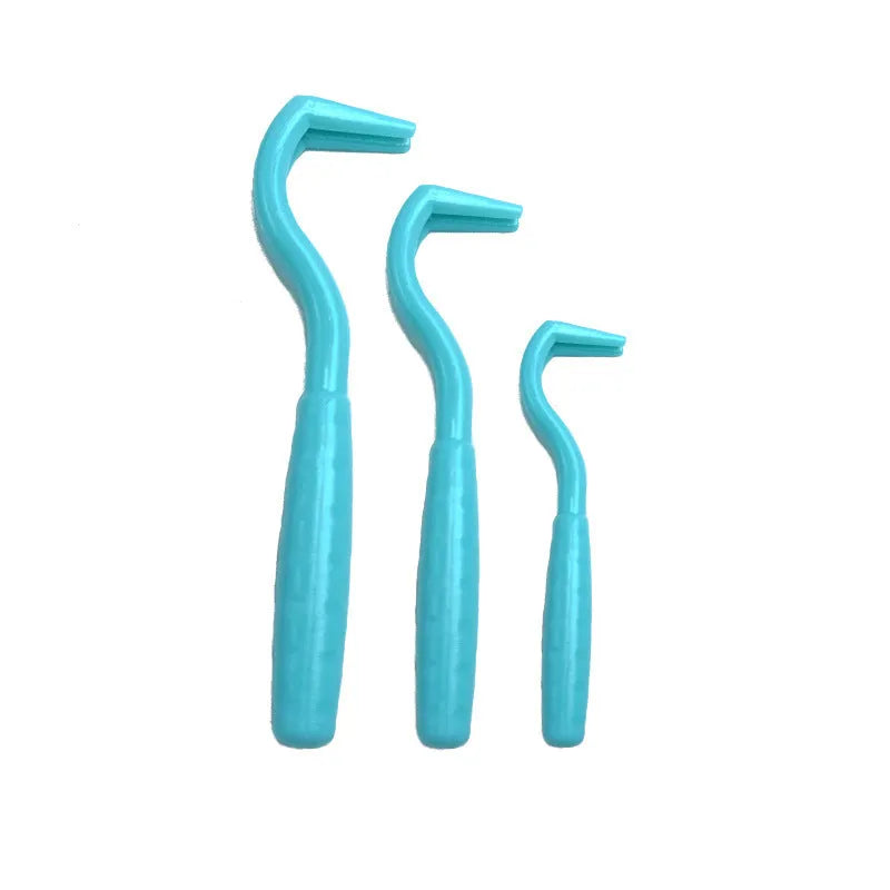 Set of three coloured tick removal hooks for dogs on a white background.