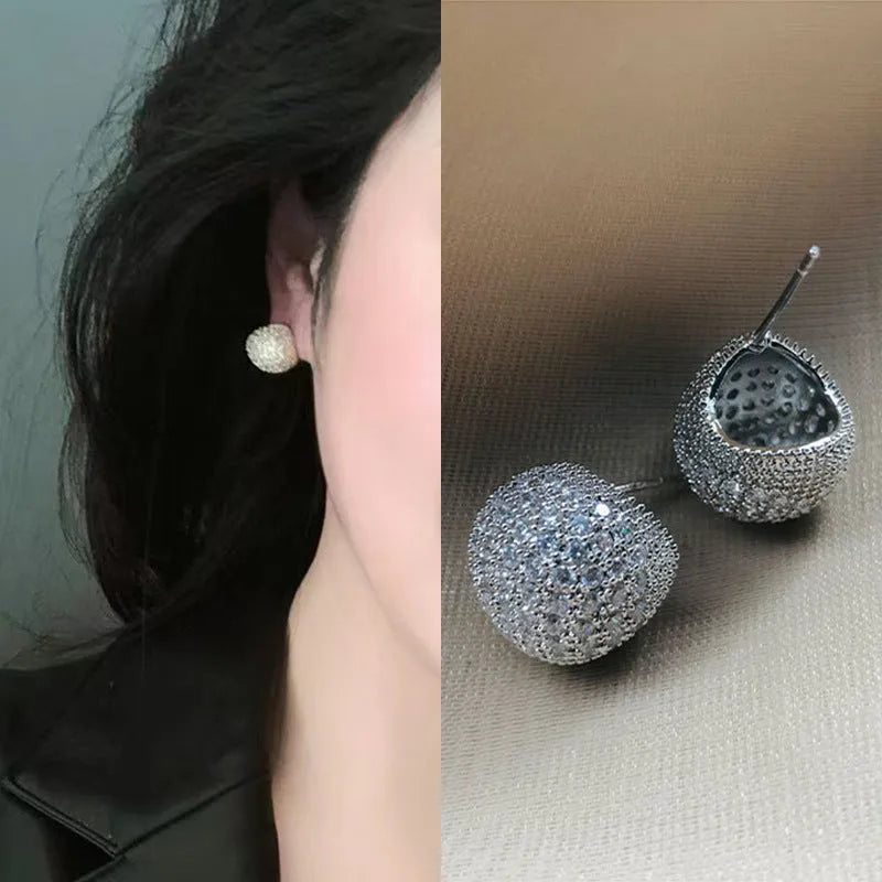 Gold and white geometric drop earrings with sparkling diamond-cut bean spheres.