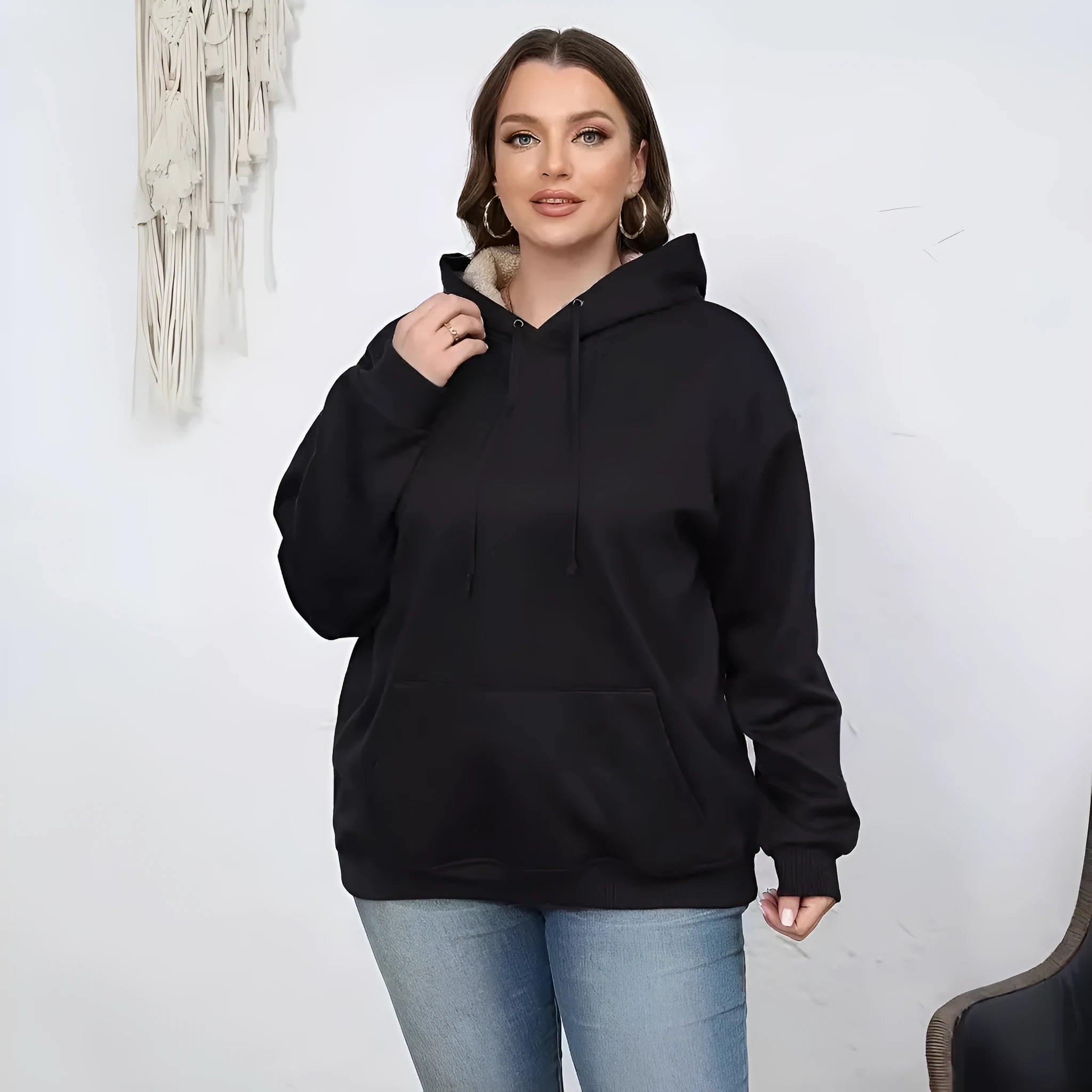 A women's loose fit hooded sweater in thick grey polyester with side pockets and long sleeves.