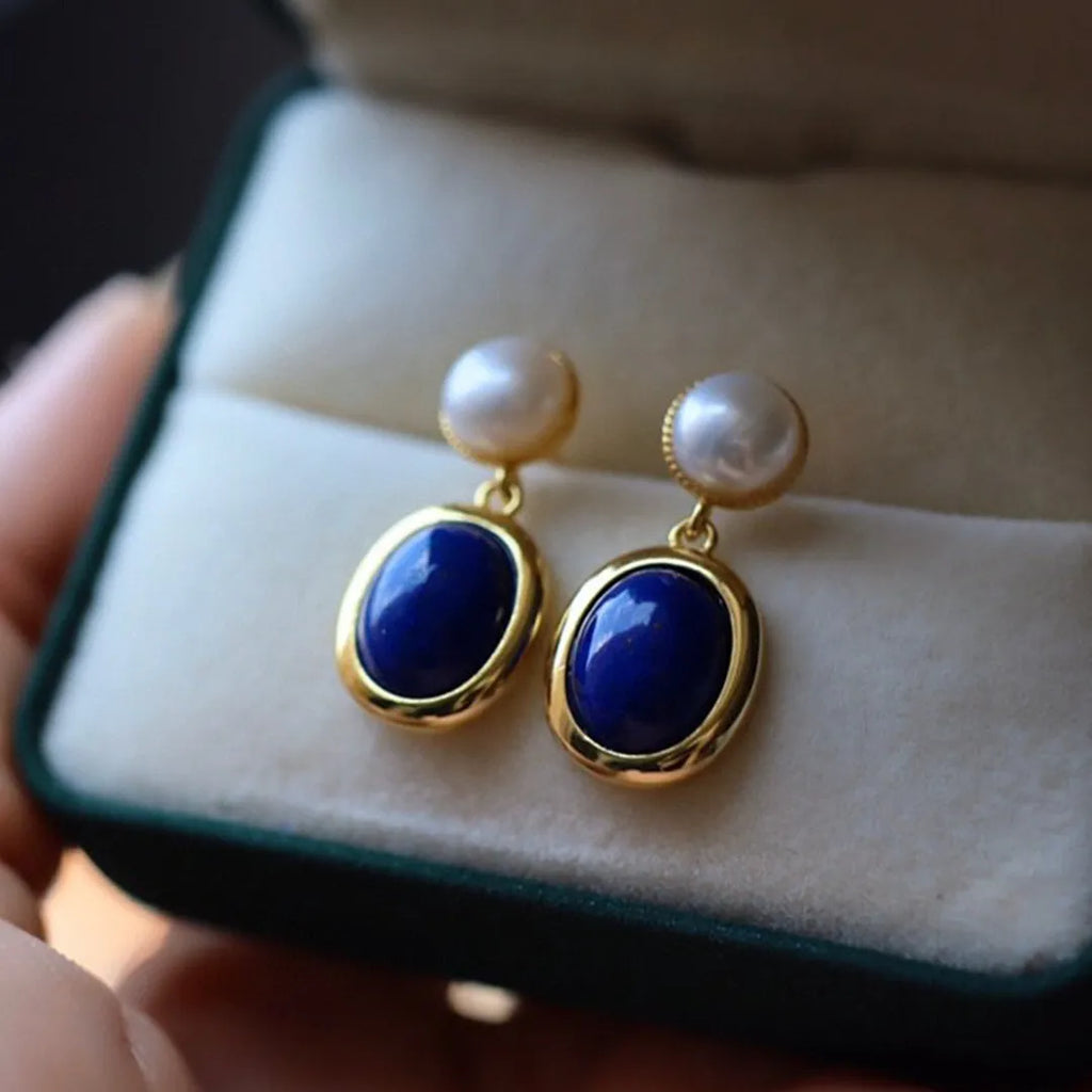 A pair of simple silver earrings with blue lapis lazuli pearls and auspicious patterns.