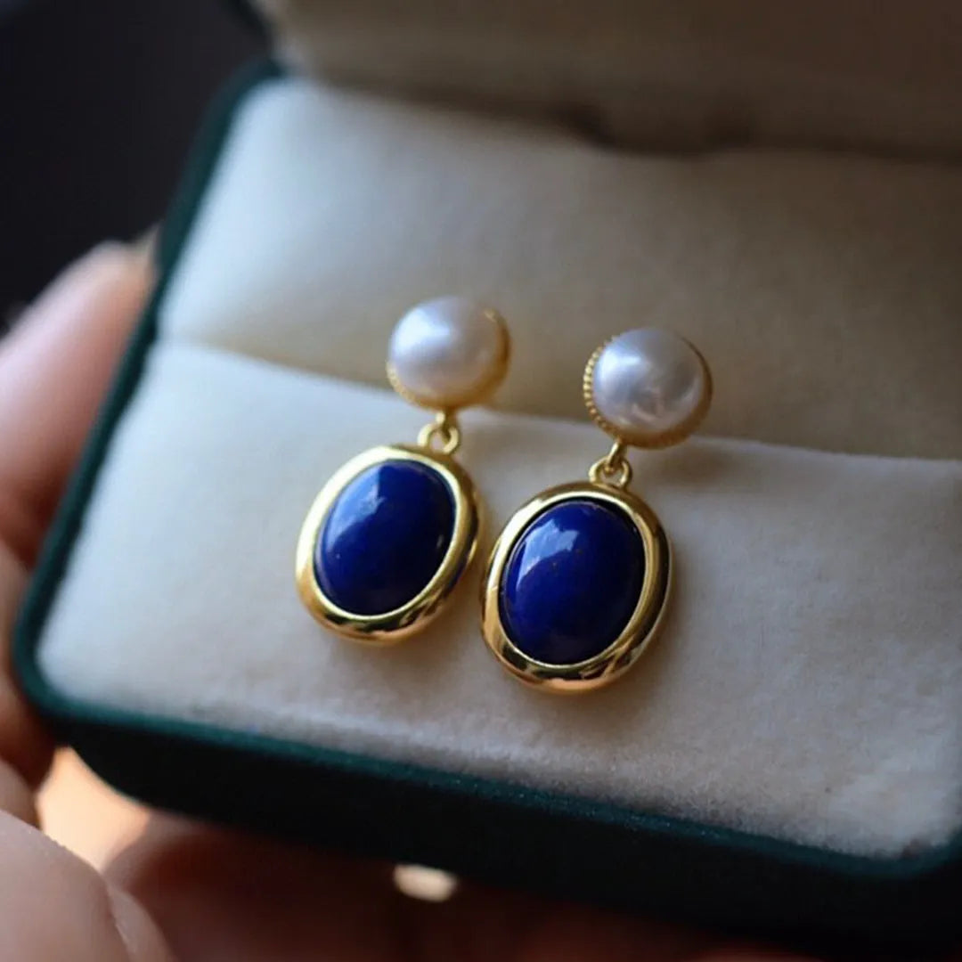 A pair of simple silver earrings with blue lapis lazuli pearls and auspicious patterns.