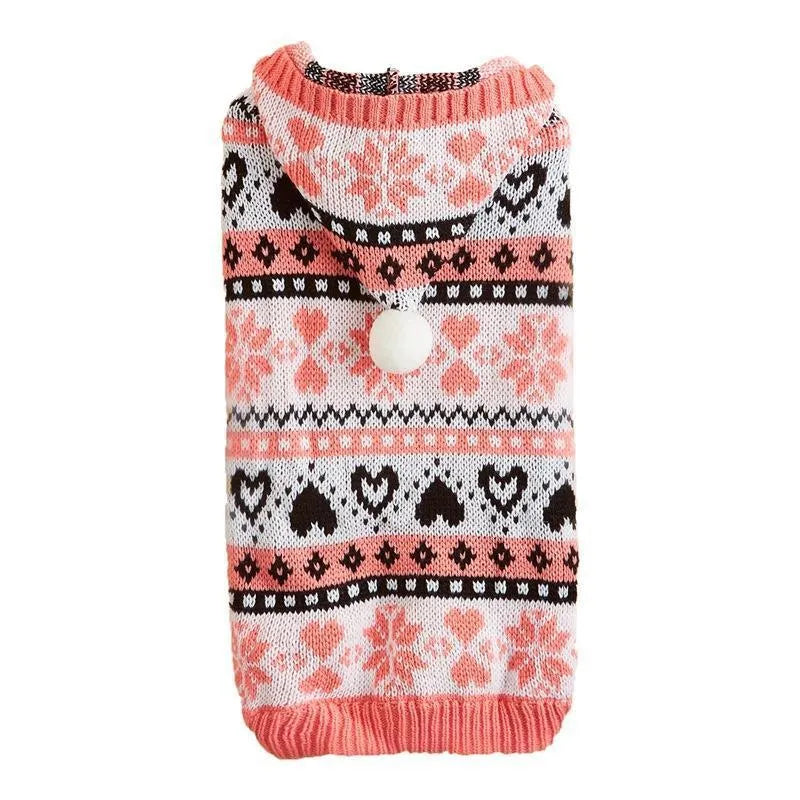 Pink striped dog sweater with snowflake and heart patterns on a small white Bichon