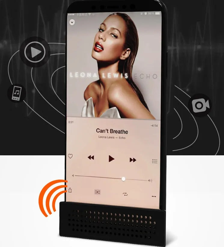 A small, coloured ABS plastic phone amplifier holder on a desktop, holding a mobile phone horizontally.