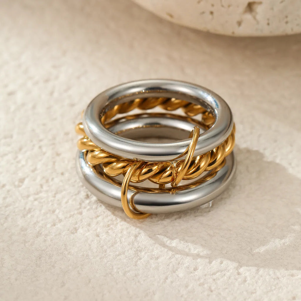 Stacked gold plated stainless steel ring set with exaggerated design on hand