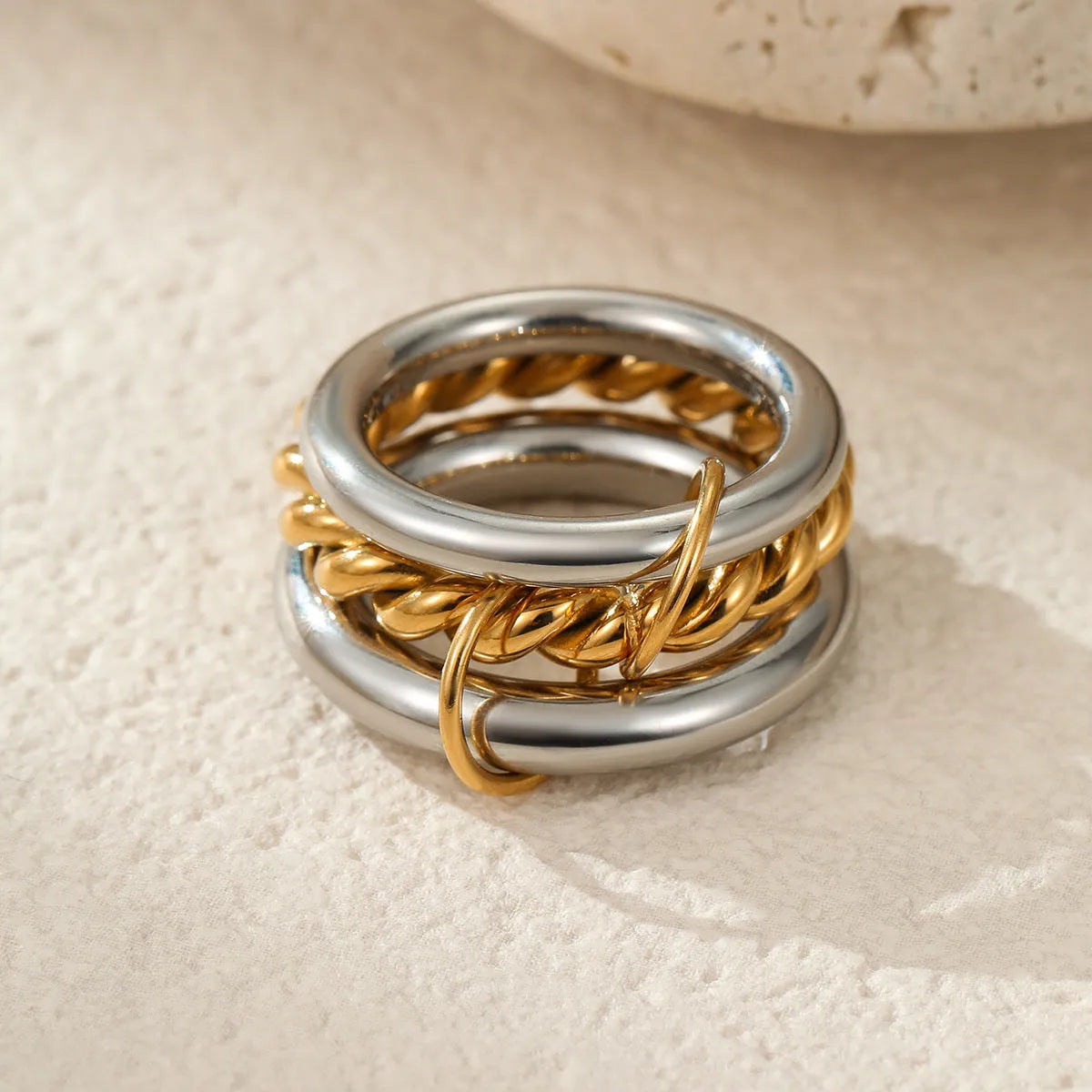 Stacked gold plated stainless steel ring set with exaggerated design on hand